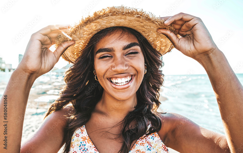 Wall mural happy black young woman smiling at camera at the beach side - beautiful african girl having fun on s