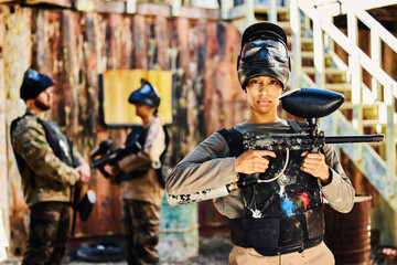 Fototapeta premium Portrait, paintball or woman with gun in game or competition for fitness, exercise or cardio workout. Focus, challenge or serious girl carrying an army weapon or marker for military target training