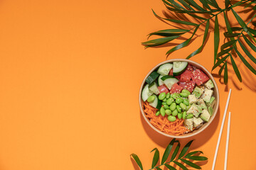 Poke bowl in cardboard containers on bright sunny background. Summer mood concept. Healthy food delivery
