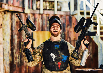 Paintball, laughing or portrait of happy man with guns in shooting game playing or celebrates...