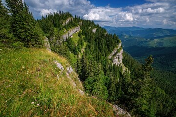Fototapeta na wymiar Beautiful mountain landscape with hills, green meadows and spruce trees. Mountain landscape during the day with blue sky and clouds - Low Tatras, NAPANT, Slovakia