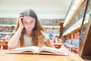 図書館で本を開いて悩むオーストラリア人少女