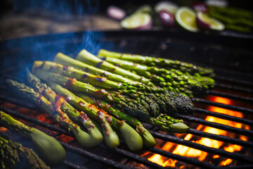 Bbq, grilled asparagus on grill grate with fire. Close-up view. Summer picnic outdoors. Created with Generative AI technology.