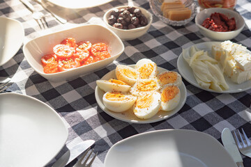 Breakfast with egg, olive, cheese, plate with cutlery