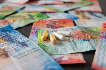 Medicines are symbolically placed on the Swiss franc banknotes. The inflation does not stop in the pharmacy either. - obrazy, fototapety, plakaty