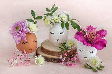 Funny Easter eggs with painted cute face and flowers