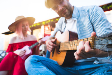 Friends have a picnic and play with guitar