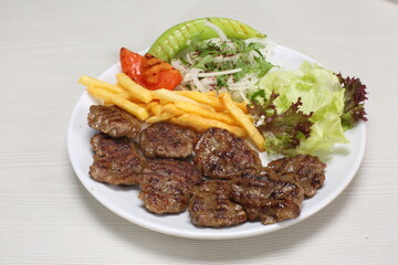 grilled meatballs with fries and onion, tomatoes, green pepper