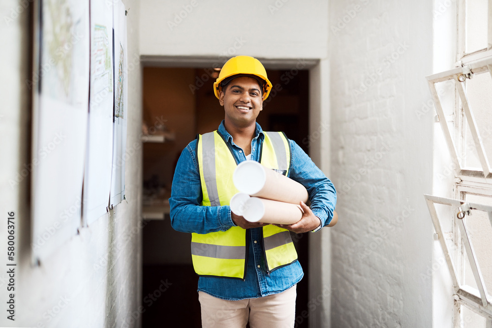 Poster I cant wait to start working on this space. Shot of a young engineer holding blueprints on a construction site.