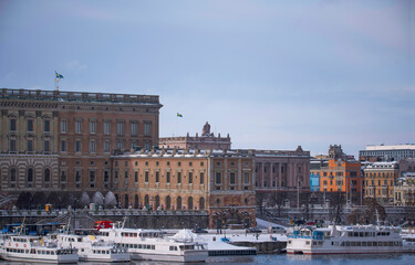 Fototapeta na wymiar Panorama, the old town Gamla Stan with churches, commuting and tourist boats, a snowy day in Stockholm
