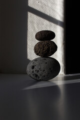 zen three stones pyramid into sun light with shadow