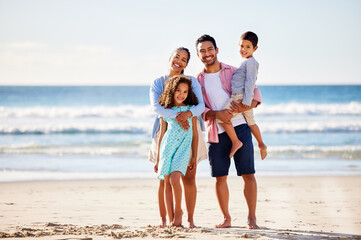 This family loves to spend summer by the beach. Shot of a young couple and their two children...