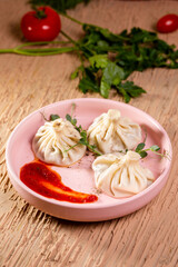 khinkali with red sauce on a plate in a restaurant.