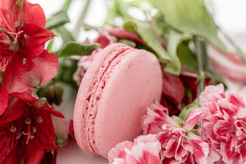 Tasty summer dessert, pink macaron, pink flowers close up. Summer vibe