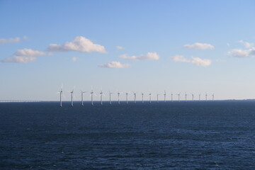 Fototapeta na wymiar Im Öresund zwischen Kopenhagen und der Öresundbrücke stehen diese Windräder in einer Reihe. Sie erzeugen Strom aus Windkraft.