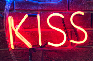 Red neon sign that says the word KISS.