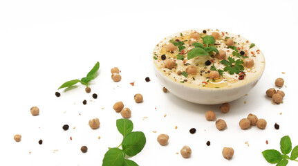 Banner with classic hummus on a white background in a plate topped with chickpeas and sesame seeds, basil, parsley and spices. Photo for culinary and food web sites. Eastern or Mediterranean cuisine