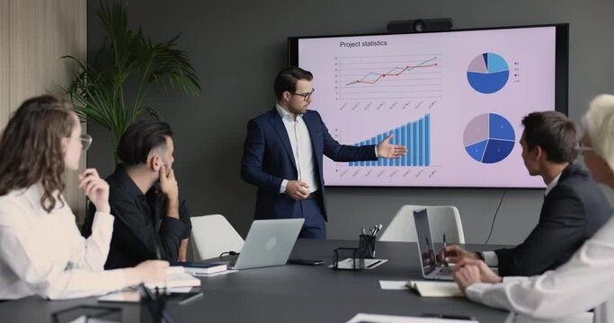 Corporate training event with charts and graphs, reviewing sales result, marketing or investment statement, project statistics during group meeting in boardroom with clients, investors or employees