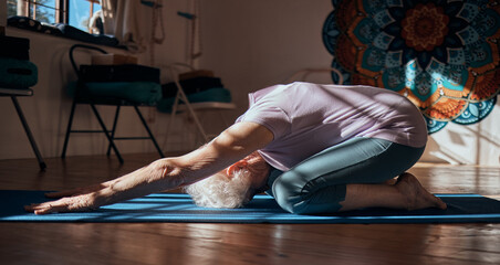 Senior woman, stretching and yoga exercise in living room for fitness, cardio and wellness on mat studio training. Retirement, workout and pilates elderly retired person exercising legs on floor