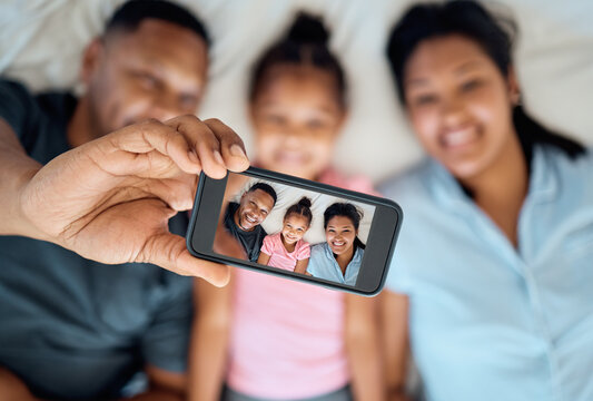 Phone, selfie and portrait of family on bed for fun, happiness and relaxing in morning. Black family, love and photo on screen of dad using smartphone with mom and girl in bedroom, enjoying weekend