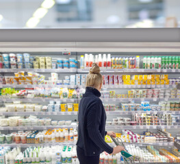 supermarket shopping,Woman choosing a dairy products at supermarket.