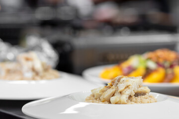 Chef cooks in kitchen restaurant fish, closeup details of preparation of dishes in frying pan and saucepan