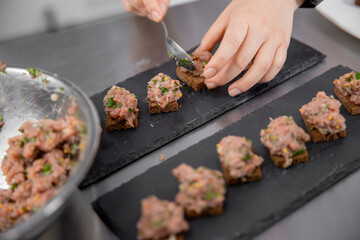 Chef cooks of French restaurant prepares steak tartare from fresh meat