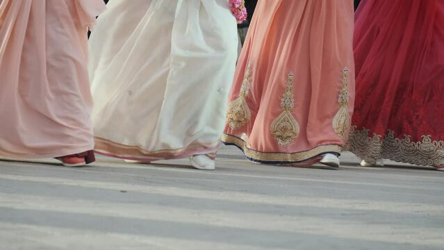 Unrecognizable Hare Krishna women dancing in traditional dresses on the street