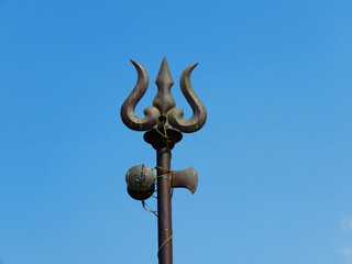 Fototapeta na wymiar Trident weapon, and ornaments of Lord Shiva. Weapon of God Shiva. Trishul and damaru drum.