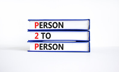P2P person to person symbol. Concept words P2P person to person on books on a beautiful white table white background. Business and P2P person to person concept. Copy space.