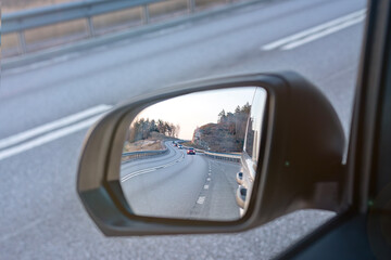 asphalt road reflected in the rearview mirror