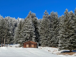 Old traditional swiss rural architecture and alpine livestock farms in the winter ambience of the tourist resorts of Valbella and Lenzerheide in the Swiss Alps - Canton of Grisons, Switzerland