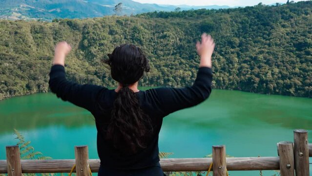 mujer latina pelo negro obsevando lago color aguamarina en calma (leyenda del dorado)