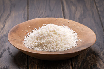 Grounded coconut flakes on wooden plate