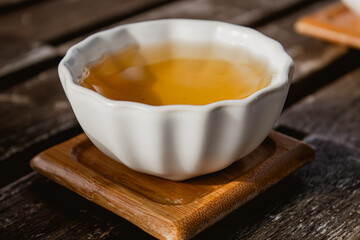 Green tea in a bow on wooden table