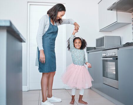 Mother, Child And Dancing In Home Kitchen For Love, Energy And Fun Together As A Family With Happiness, Care And Support. Black Woman And Girl Or Daughter With Princess Tutu To Dance While Cooking