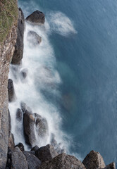rocks on coast with water splashing, long exposure