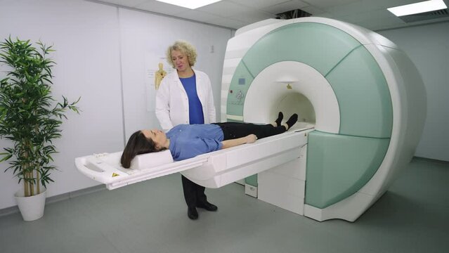 Doctor makes an MRI scan for a patient in a clinic. The patient lies in the MRI device. Modern technologies in medicine