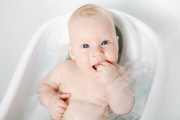 Cute baby girl taking a bath. Child health care. - 580106345