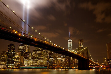 Fototapeta na wymiar Brooklyn bridge with Tribute in Light . The installation of 88 searchlights has been displayed annually in remembrance of the September 11, 2001 attacks.