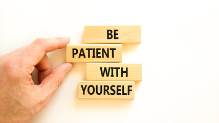 Patient with yourself symbol. Concept words Be patient with yourself on wooden blocks. Beautiful white table white background. Businessman hand. Business patient with yourself concept. Copy space.