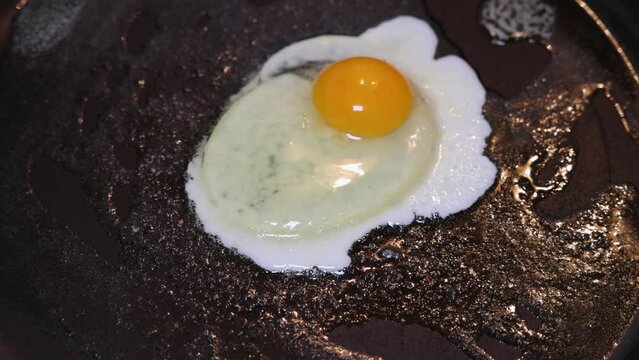 An egg is placed in the pan and fried until it is a fried egg.