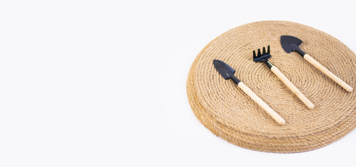 miniature gardening tools on twine background. Space for text on the left