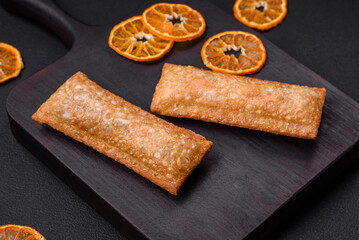 Delicious fresh crispy pie with cherry jam on a wooden cutting board