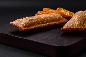 Delicious fresh crispy pie with cherry jam on a wooden cutting board