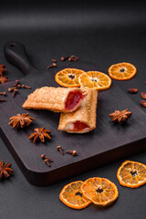 Delicious fresh crispy pie with cherry jam on a wooden cutting board