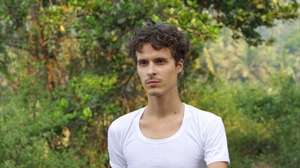 Naklejka na ściany i meble male model in a white tee shirt walks in the tropics