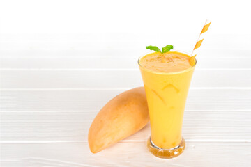Mango smoothies yellow colorful fruit juice milkshake blend beverage healthy high protein the taste yummy In glass,drink to lose weight drink episode morning on white gray background.