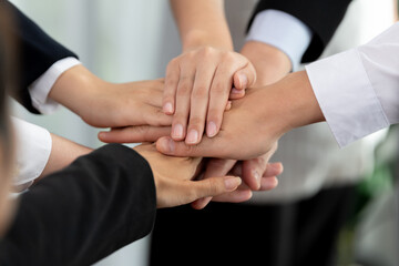 Top view closeup business team of suit-clad businesspeople join hand stack together. Colleague...