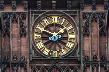 A gilded clock face on an ancient tower